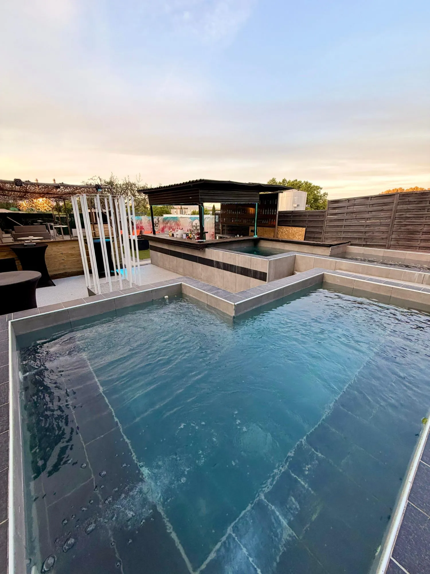 Le bar extérieur et la piscine du Club L’Impasse au coucher du soleil, avec la Sainte-Victoire au loin